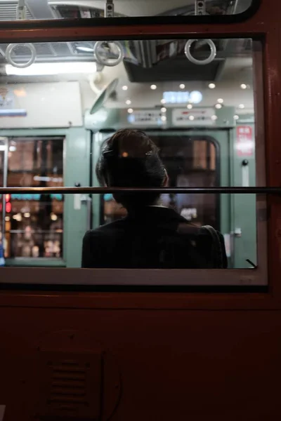 Primer plano selectivo vertical de una persona apoyando la cabeza en la ventana de un autobús —  Fotos de Stock