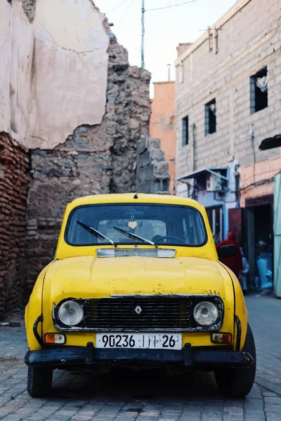 Voiture jaune devant les bâtiments endommagés à Marrakech — Photo