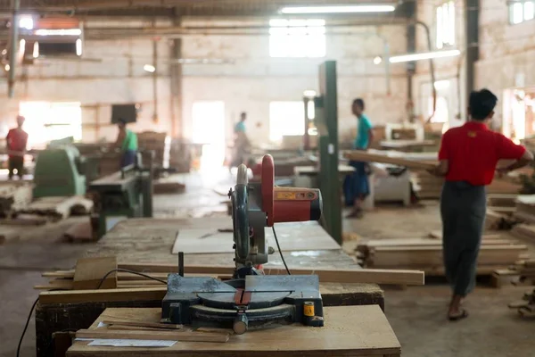 Bulanık arka plana sahip bir fabrikada ahşap kesme makinesinin yakın çekimi — Stok fotoğraf