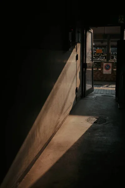 Vertical shot of a pathway with brown walls and an open door — Stock Photo, Image