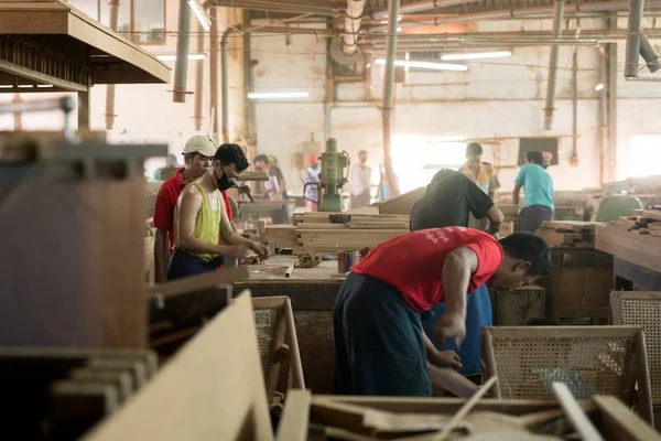 Bulanık arka planlı bir ahşap fabrikasında çalışan kişilerin yakın çekimi — Stok fotoğraf