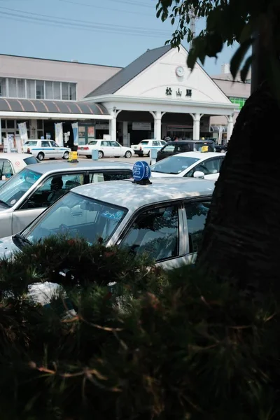 건물 근처 주차장에 주차 된 자동차와 택시의 수직 샷 — 스톡 사진