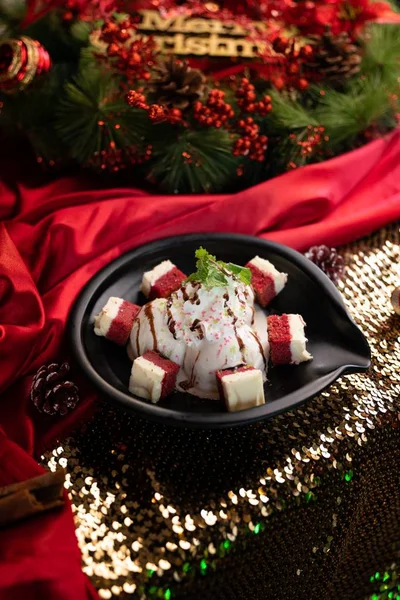 Verticaal shot van een dessert met ijs en gebak in een zwarte kom op een rode deken — Stockfoto