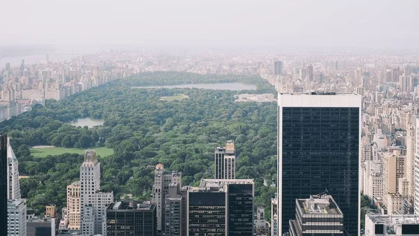 An aerial photo of Central Park with a lot of high-rise buildings and trees covered in fog