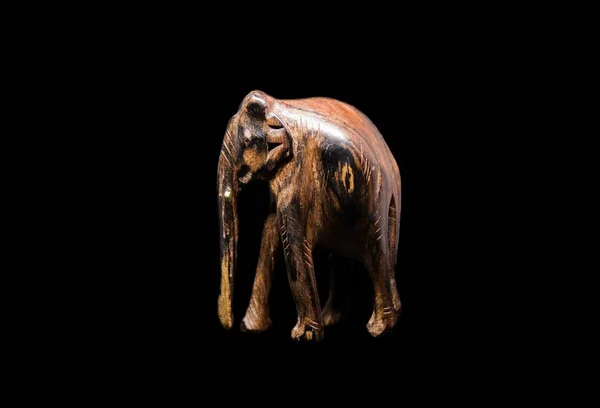 Скульптура коричневого слона на черном фоне — стоковое фото