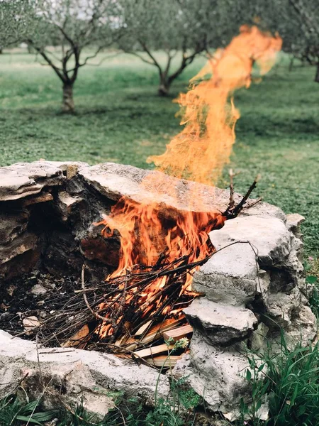 Tiro vertical de varas ardentes em uma fogueira em um campo — Fotografia de Stock