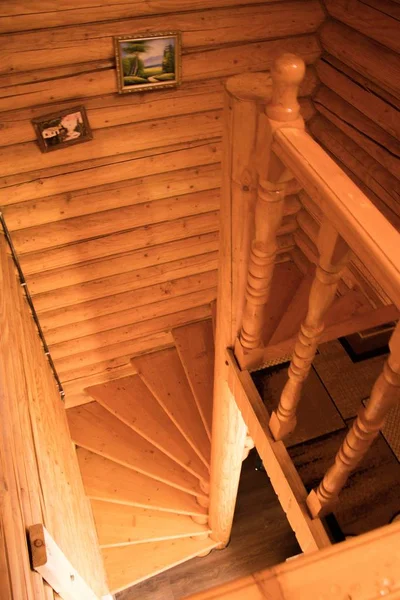 A high angle shot of staircases made of plywood with two pictures hanging on the wall