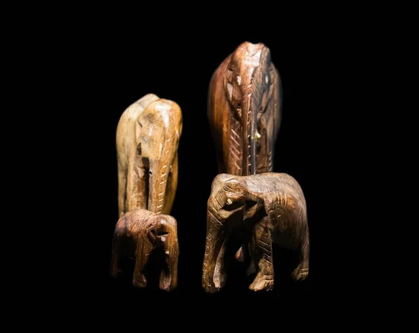 Sculptures of four elephants with a black background