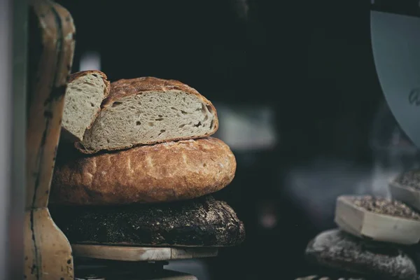 Closeup tiro de pão em uma bandeja de madeira com um fundo desfocado — Fotografia de Stock