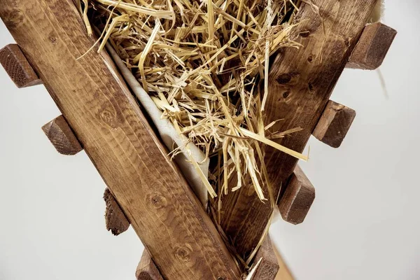 白い背景に干し草のスタックを持つ孤立した古い木製の揺りかごの美しいショット — ストック写真