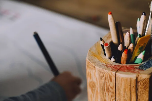 Close shot van kleurpotloden in een houten potje met een onscherpe achtergrond — Stockfoto
