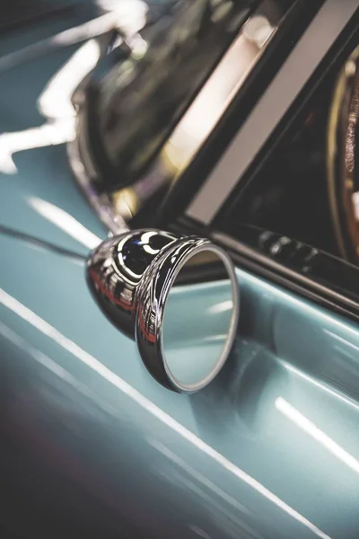 Vertical shot of an old cars side mirror with a blurred background — Stock Photo, Image