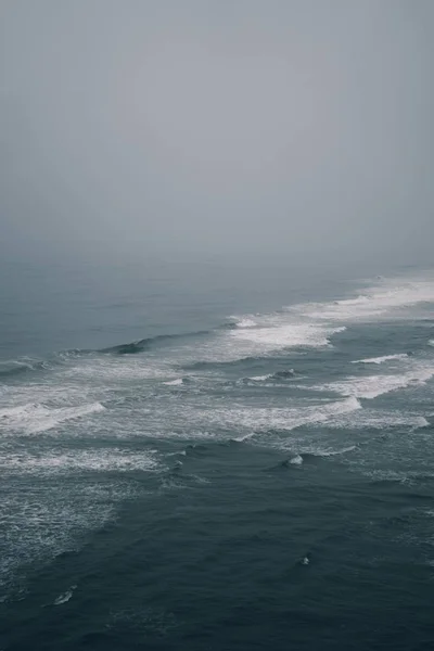 Lindo tiro de uma praia de areia com ondas incríveis em um dia ensolarado — Fotografia de Stock