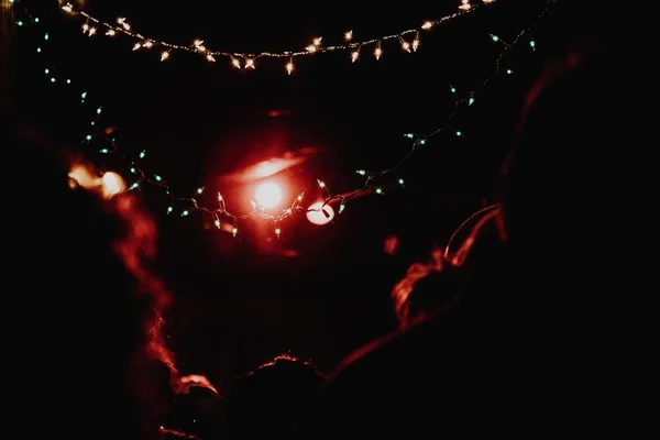 A horizontal shot of white string lights turned on at nighttime