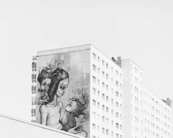 A beautiful shot of a graffiti on a big building with a clear sky in the background in black and white