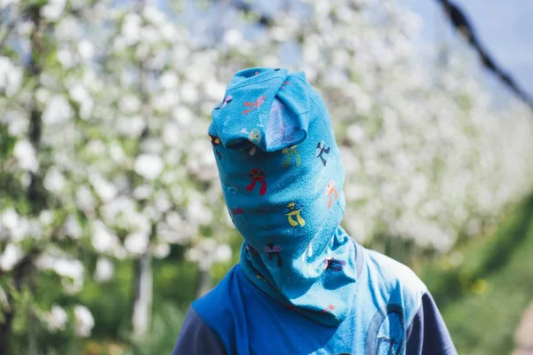 Plan rapproché d'un enfant portant une chemise bleue et un masque avec un fond flou — Photo