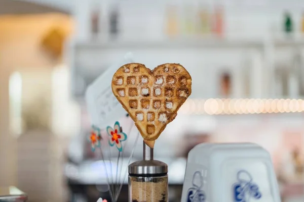Close shot of a heart-shaped waffle with a blurred background