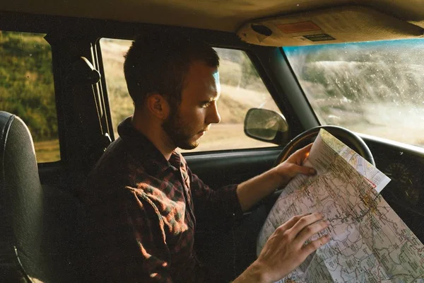 지도를 보고 어디로 가야 할지 결정하는 그의 차량에 있는 남성 — 스톡 사진