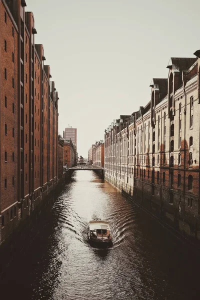 Tiro Vertical Barco Água Meio Edifícios Sob Céu Limpo — Fotografia de Stock