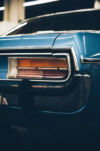 ぼやけた背景を持つ青いヴィンテージカーのバックライトの垂直ショット — ストック写真