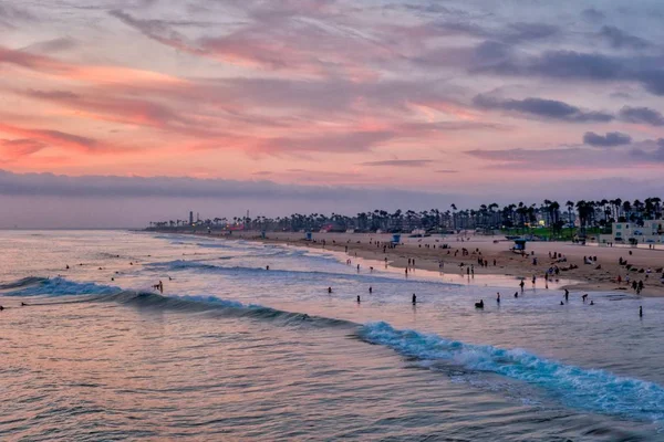 カリフォルニア州ハンティントンビーチの夕日とサーファー 美しい空と太平洋の海岸線 — ストック写真