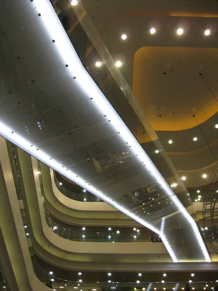 A vertical low angle shot of a lighted interior of a building with several floors