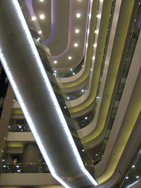 A vertical low angle shot of a lighted interior of a building with several floors