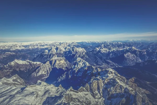 An aerial shot of rocky mountains with the background of beautiful blue sky