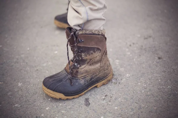 背景がぼやけた泥だらけのブーツで人の足の終わりのショット — ストック写真