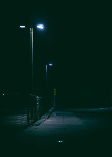 Вертикальный снимок освещённой уличной лампы ночью — стоковое фото
