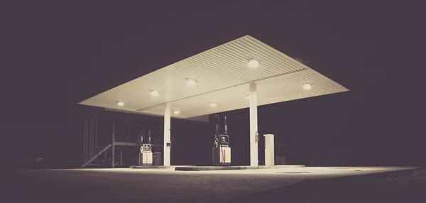 Низький кут пострілу порожньої бензинової станції з вогнями в нічний час — стокове фото