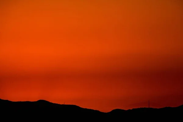 Paisagem tiro do céu durante o pôr do sol com montanhas e linhas de energia visíveis no fundo — Fotografia de Stock