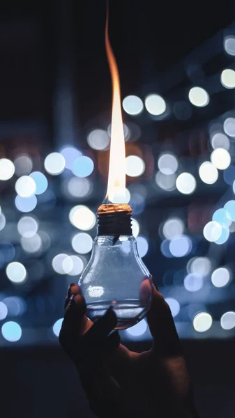 Vertikální selektivní ostření záběru osoby držící hořící olejovou lampu — Stock fotografie