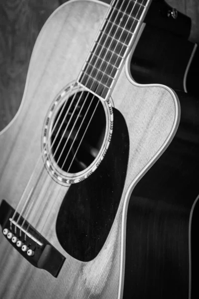 나무로 된 문에 기대어 있는 음향 기타의 아름다운 회색 칼 사진 — 스톡 사진