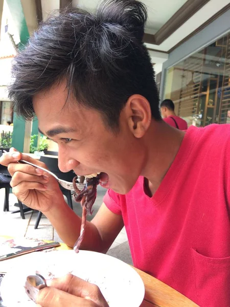 Primer plano vertical de un hombre comiendo mariscos —  Fotos de Stock