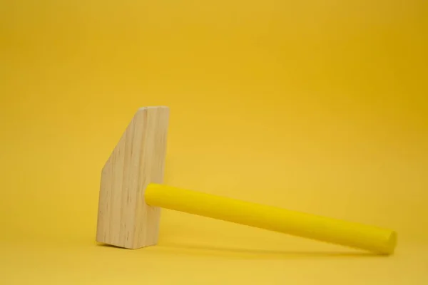 Martelo marrom e amarelo sobre um fundo amarelo — Fotografia de Stock