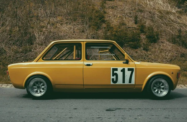 大范围拍摄的经典汽车的号码517在柏油和青草山的背景 — 图库照片