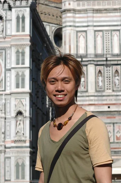 Selektivní snímek usměvavého muže stojícího na pozadí florentské katedrály v Itálii — Stock fotografie