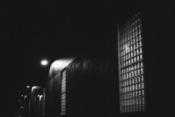 Černobílý záběr různých architektonických budov v noci — Stock fotografie