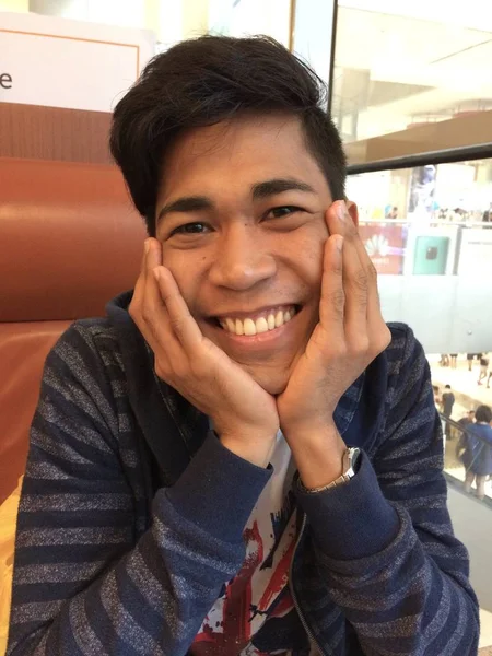 Tiro vertical de um homem feliz sorrindo e agindo bonito na frente da câmera — Fotografia de Stock