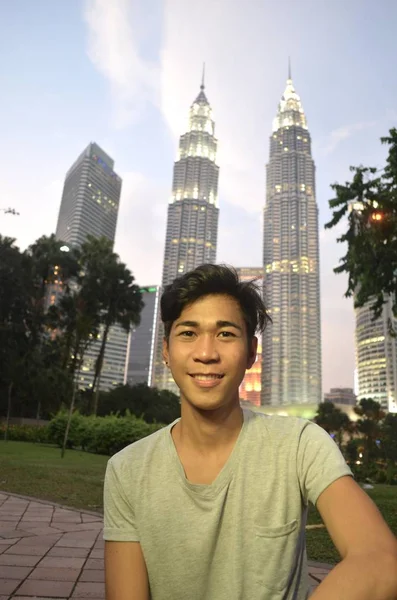 Vertikální snímek muže na pozadí Petronas Twin Towers v Kuala Lumpur, Malajsie — Stock fotografie