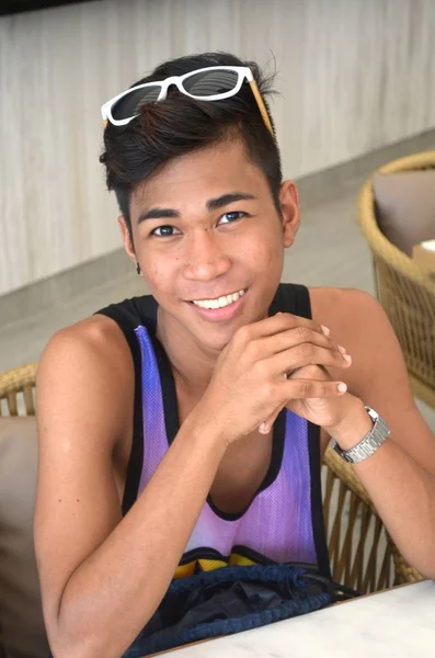 Foto vertical de un hombre sonriente con camisa sin mangas, gafas de sol y un reloj de pulsera — Foto de Stock