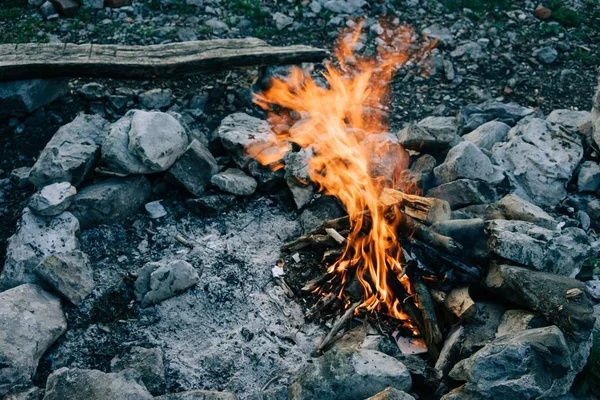 Schöne Aufnahme eines Lagerfeuers in der Nähe von Felsen mit verschwommenem Hintergrund — Stockfoto