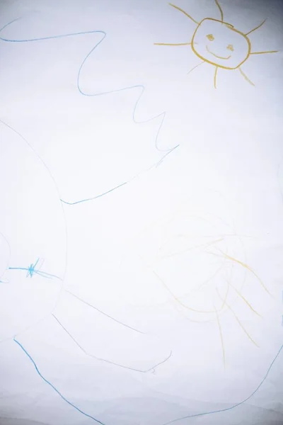Вертикальный снимок белой бумаги с рисунком солнца и красочными царапинами — стоковое фото