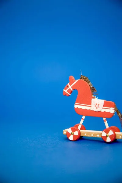 Κάθετη κοντινή λήψη από ένα κόκκινο ξύλινο παιχνίδι άλογο με μπλε φόντο — Φωτογραφία Αρχείου