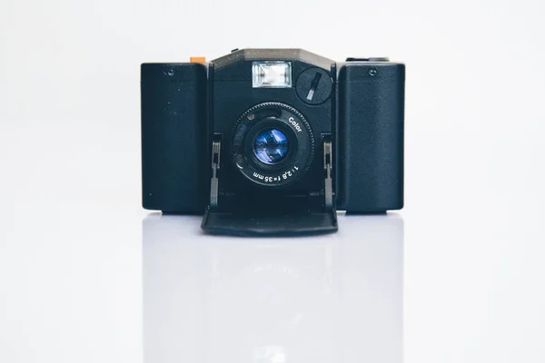 Крупним планом знімок чорної бездзеркальної взаємозамінної лінзи камери на білій поверхні — стокове фото