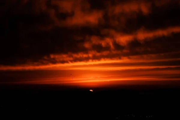 Eine Silhouette Von Bergen Unter Einem Orangefarbenen Bewölkten Himmel — Stockfoto