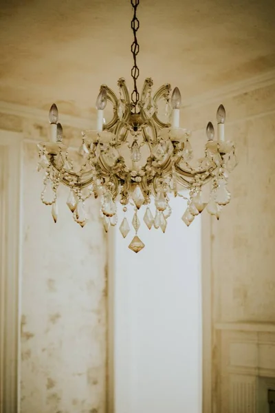 Vertical shot of a beige luxurious chandelier hanging from a ceiling — Stock Photo, Image
