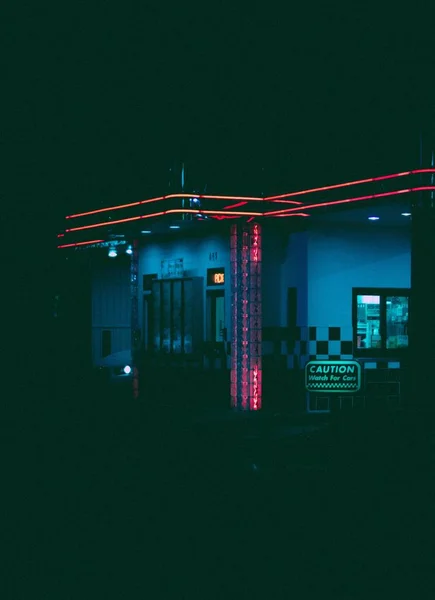 Vuelo vertical de una gasolinera con luces neón durante la noche. — Foto de Stock