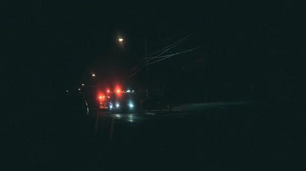 Wide shot of vehicles on a street with lighted street lamps during nighttime — Stock Photo, Image